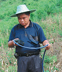 Ο Ζενγκ Φουπίνγκ ενώ ελέγχει την υγρασία του εδάφους στο Χουαντζιάνγκ, στην αυτόνομη περιοχή Γκουανσί Τζουάνγκ. [Η φωτογραφία παρέχεται στην China Daily]
