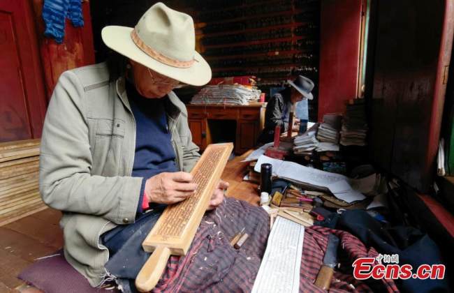 Συνεχιστές της τέχνης της ξυλοτυπίας ελέγχουν τις εργασίες του Τυπογραφείου Ντέργκε Σούτρα, στην κομητεία Ντέργκε, της αυτόνομης περιφέρειας των θιβετιανών Γκάρζε, στην επαρχία Σιτσουάν στις 20 Ιουλίου 2021